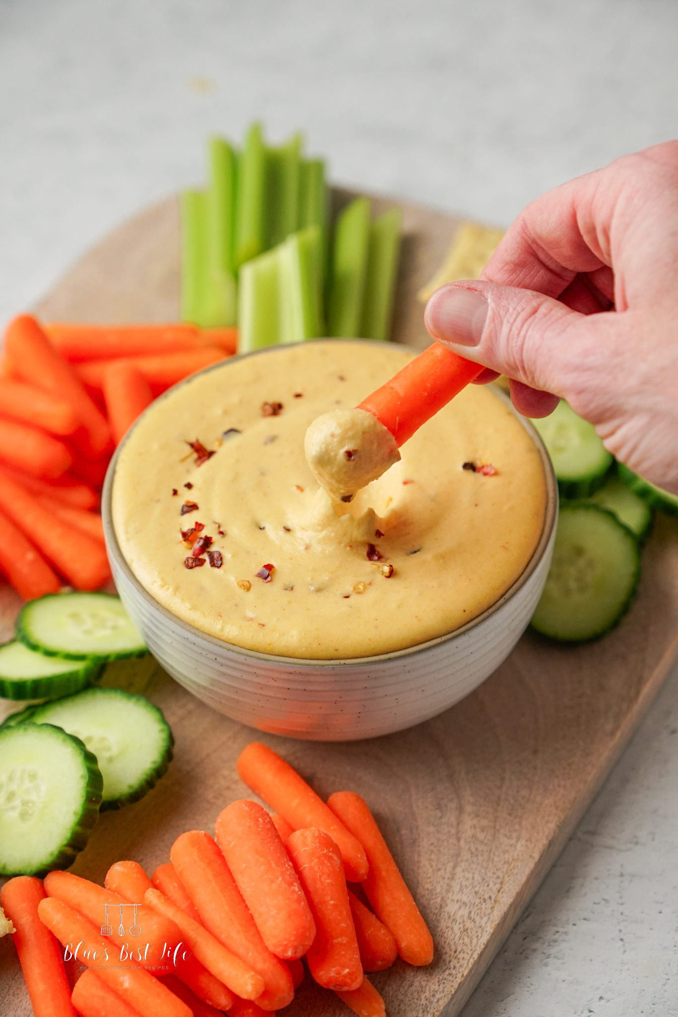 Dipping a carrot into the beer cheese dip. 