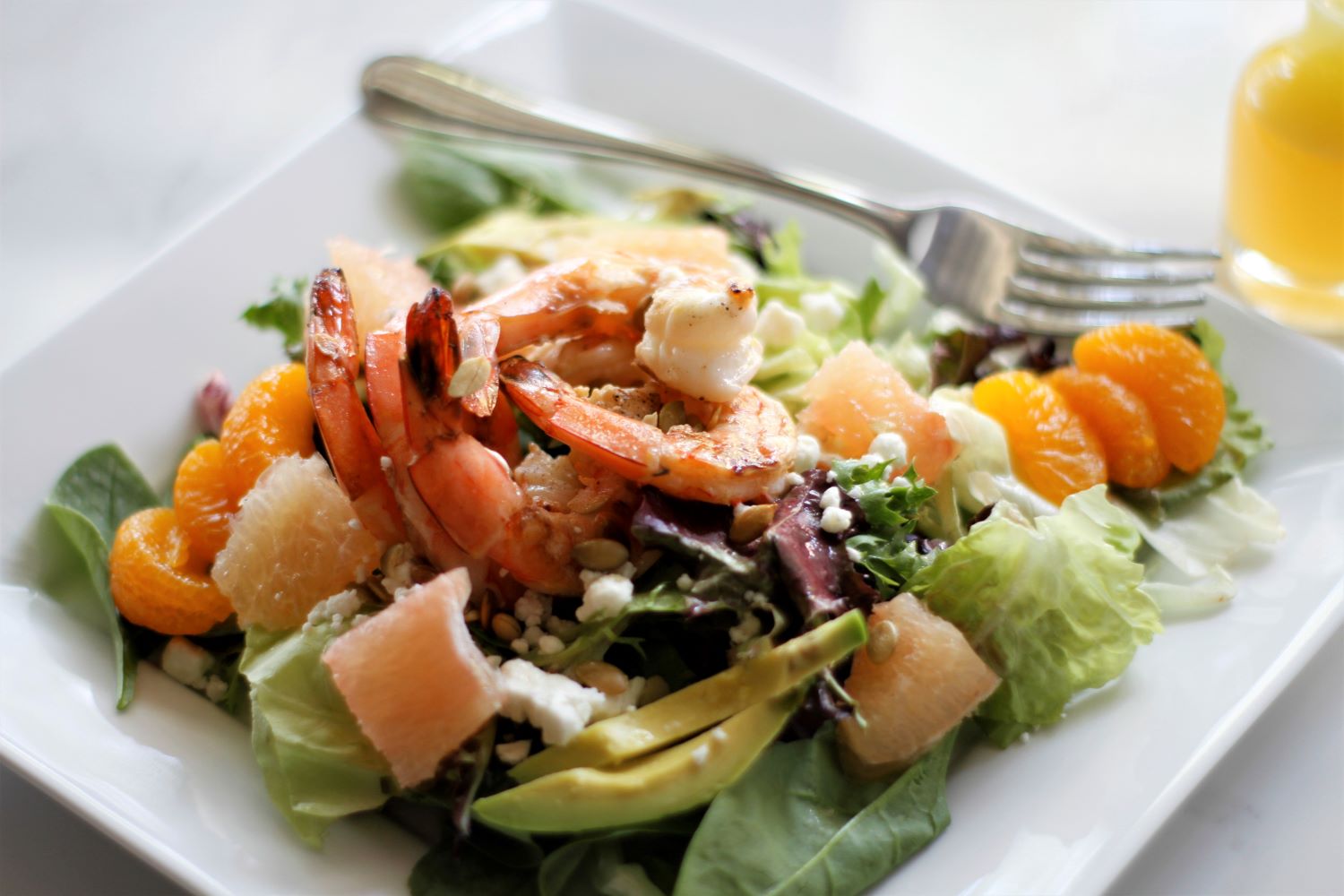 Grilled shrimp in a salad with avocado, grapefruit, madarin oranges and goat cheese