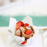 an individual French toast muffin in a parchment cup