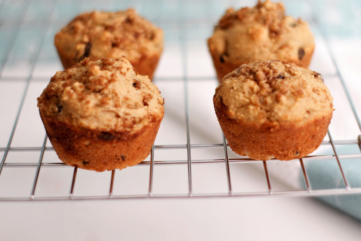 four raisin cinnamon muffins cooling on a wire rack