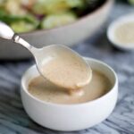 A spoonful of sesame salad dressing in a small bowl.