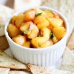 a bowl with peach salsa and chips