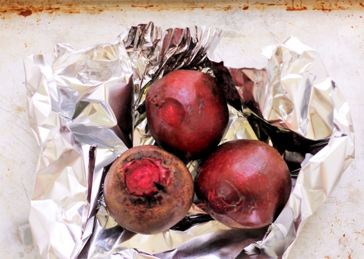 washed beets wrapped in foil to be roasted in the oven