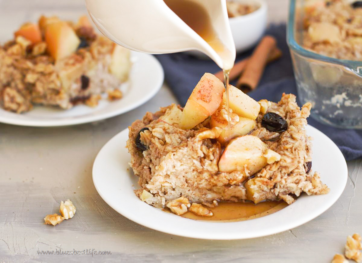 baked apple oatmeal with maple syrup being drizzled over top