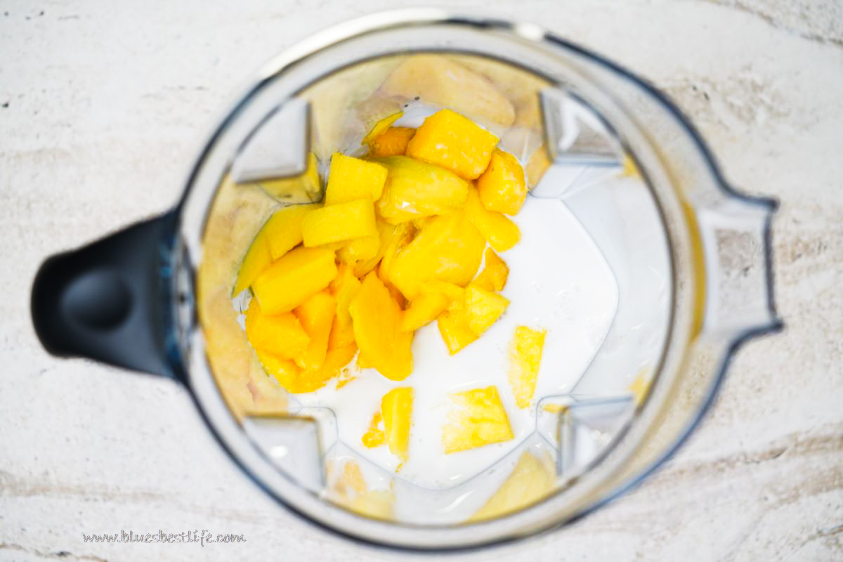 mango chunks with coconut milk and maple syrup in a vitamix