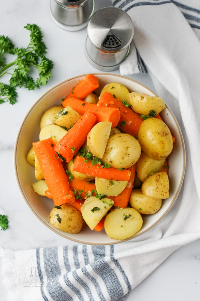 potatoes and carrots in a serving dish with parsley sprinkled on top.  