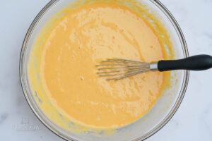 mixing together the pumpkin puree, eggs and milk in a large bowl