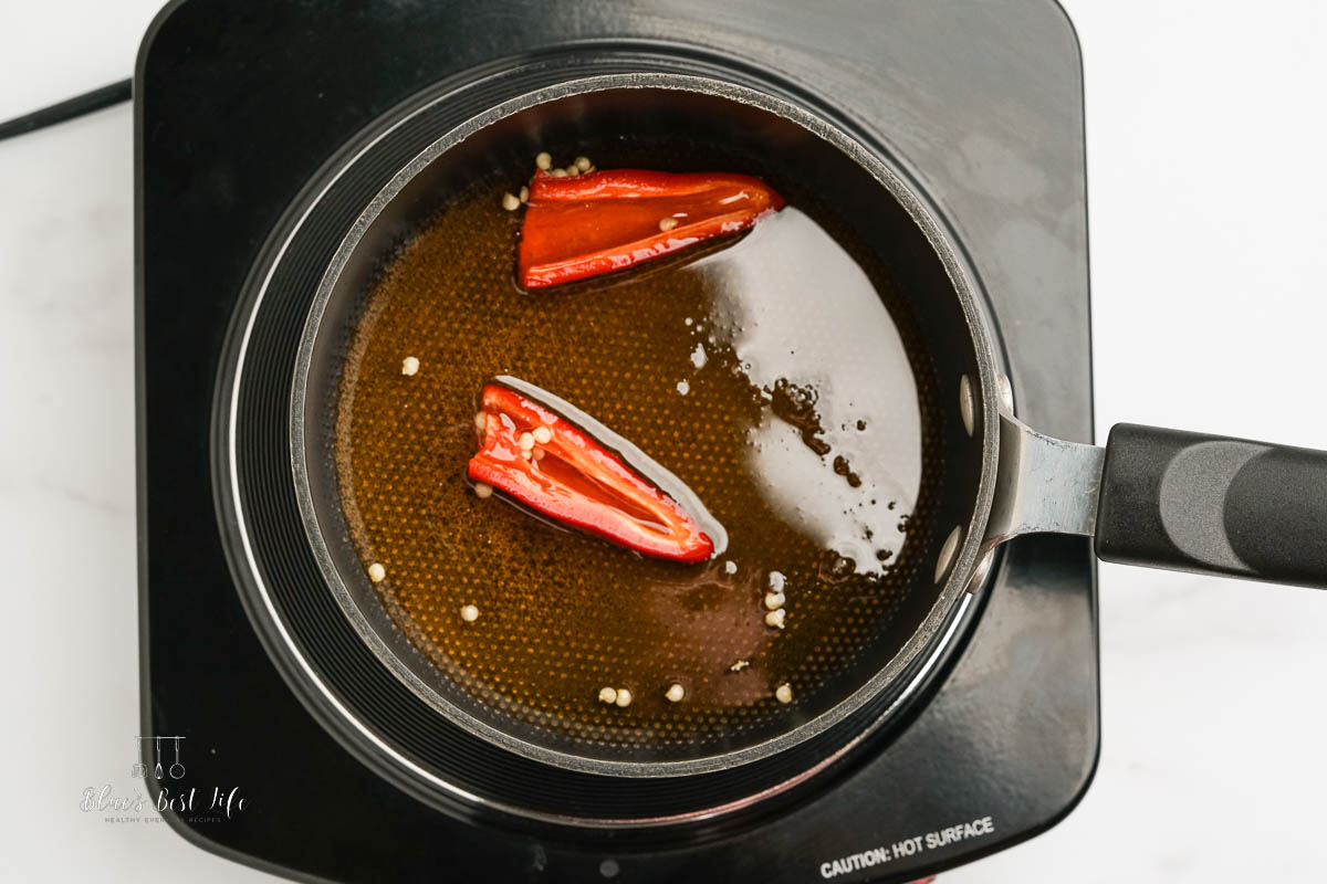 warming honey on stove top with sliced pepper 