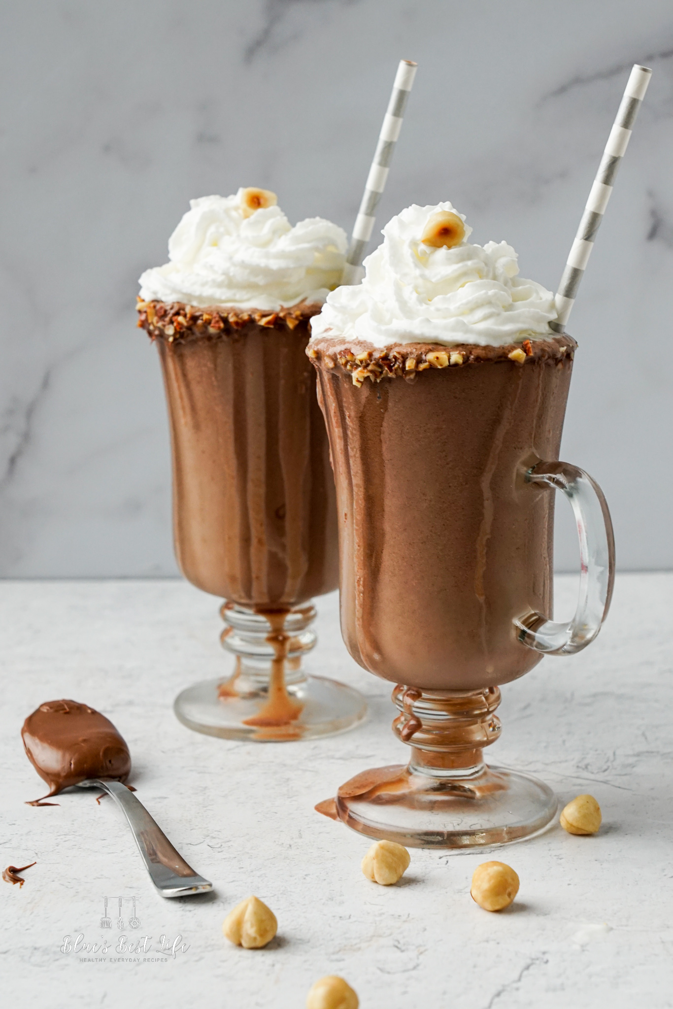 Two glasses decorated and filled with Nutella milkshake. 