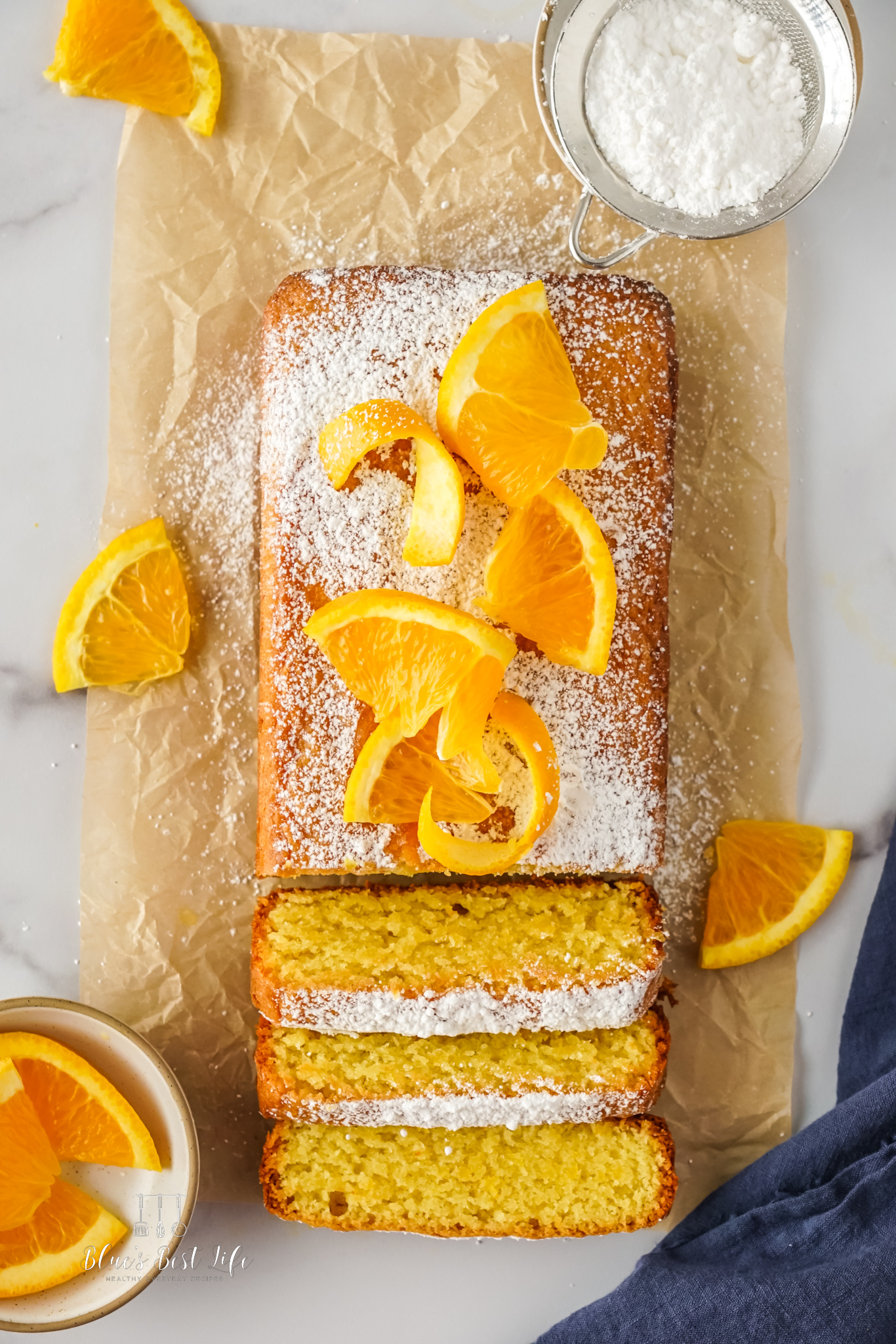 The olive oil cake decorated with orange slices and sliced. 