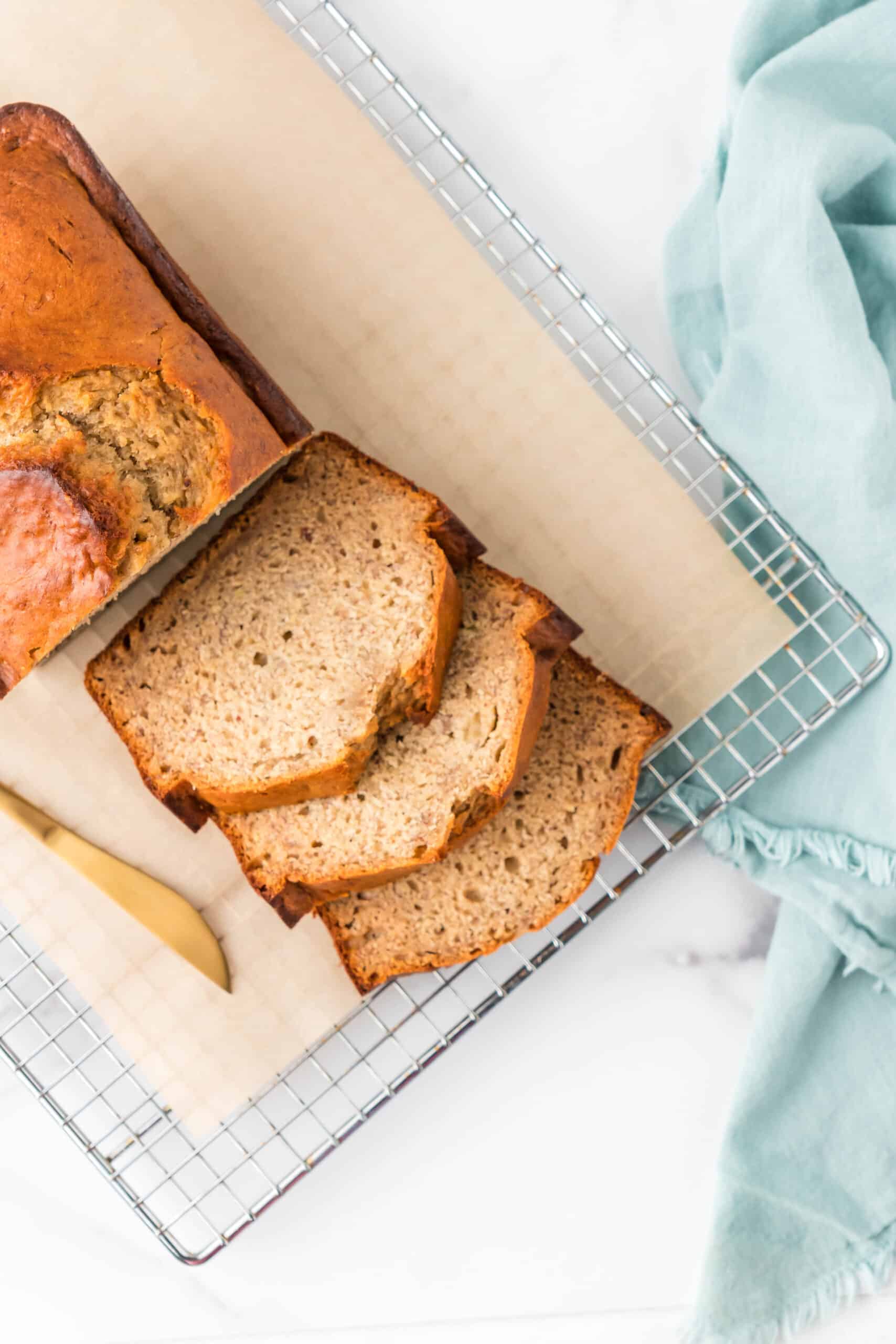The banana almond butter bread sliced on a wire cooling rack.