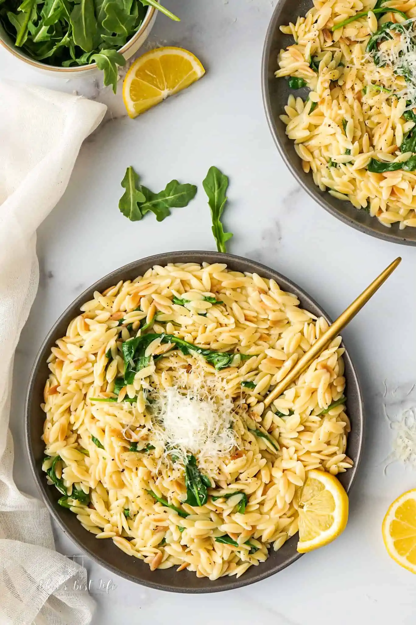 A plate with Instant pot orzo with Parmesan cheese sprinkled on top.