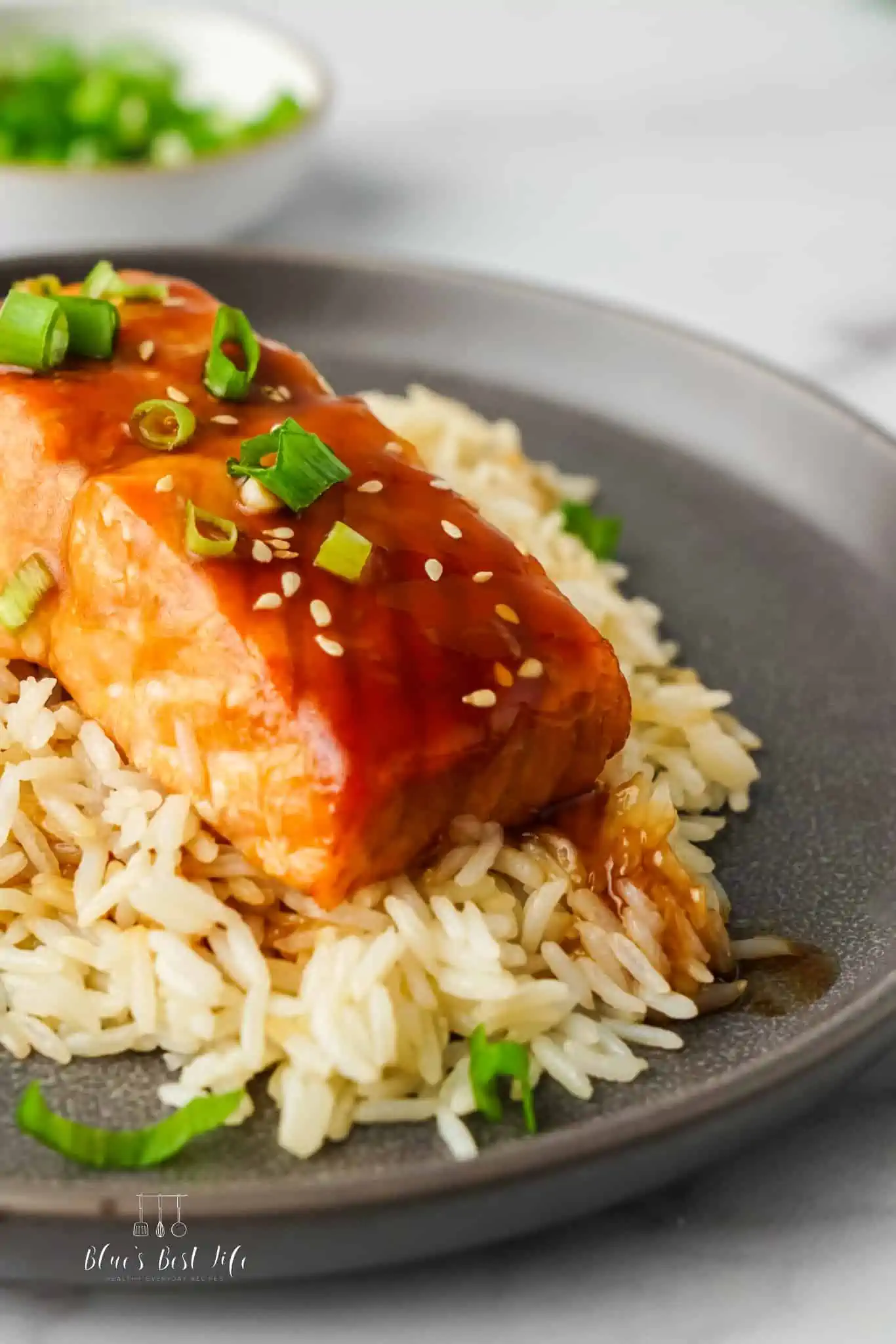 Teriyaki salmon cooked in an air fryer plated with rice. 