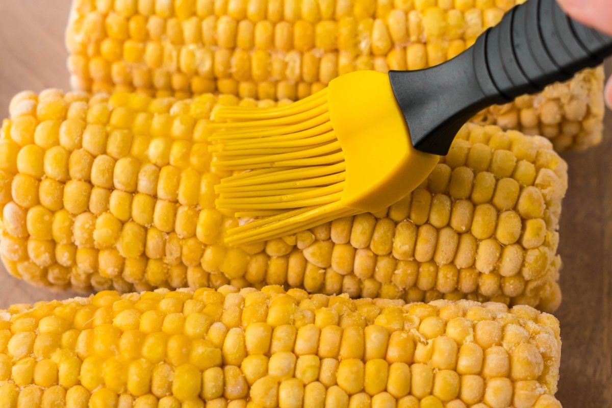 Brushing corn with olive oil. 