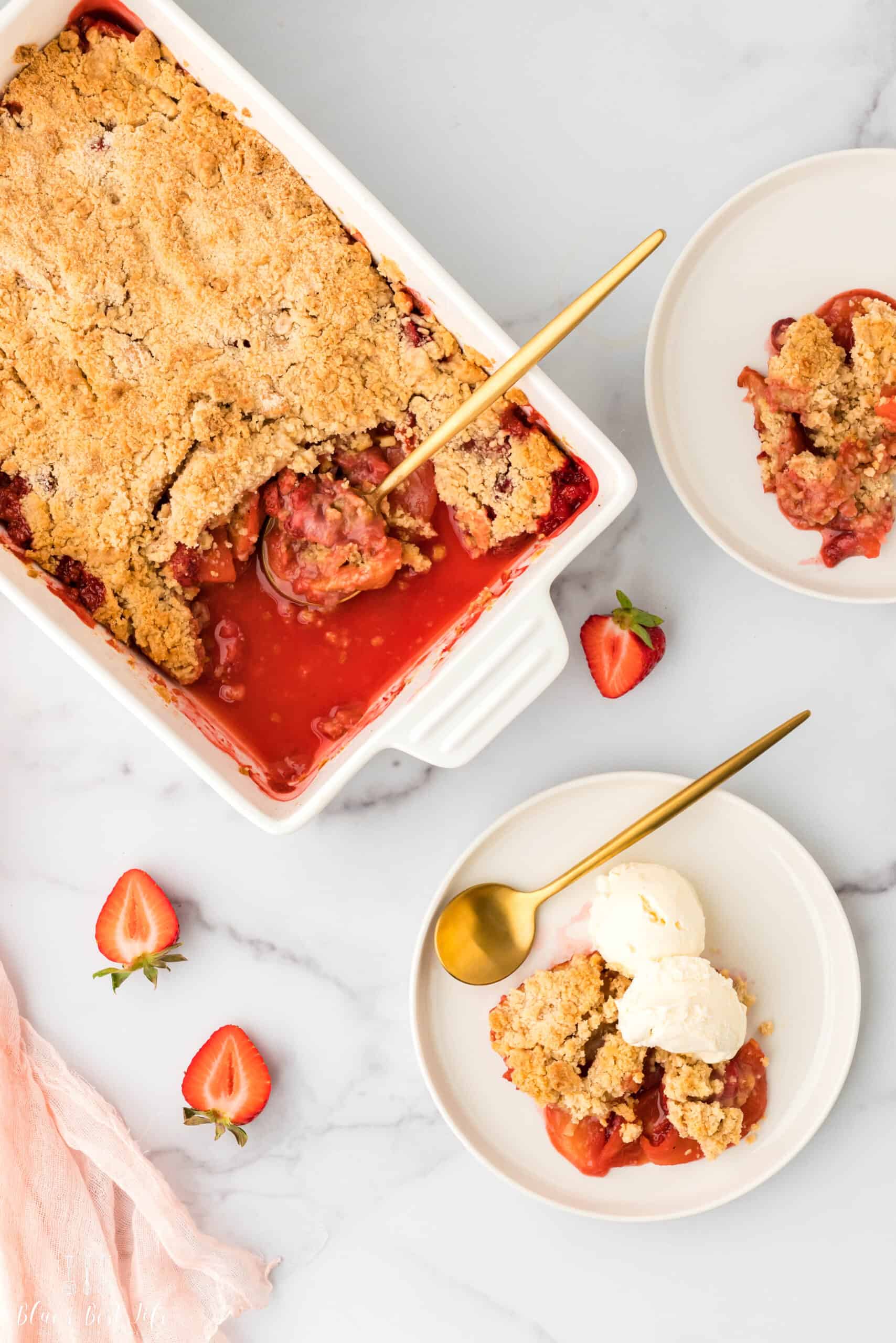 A scoop of cobbler on a plate with vanilla ice cream.