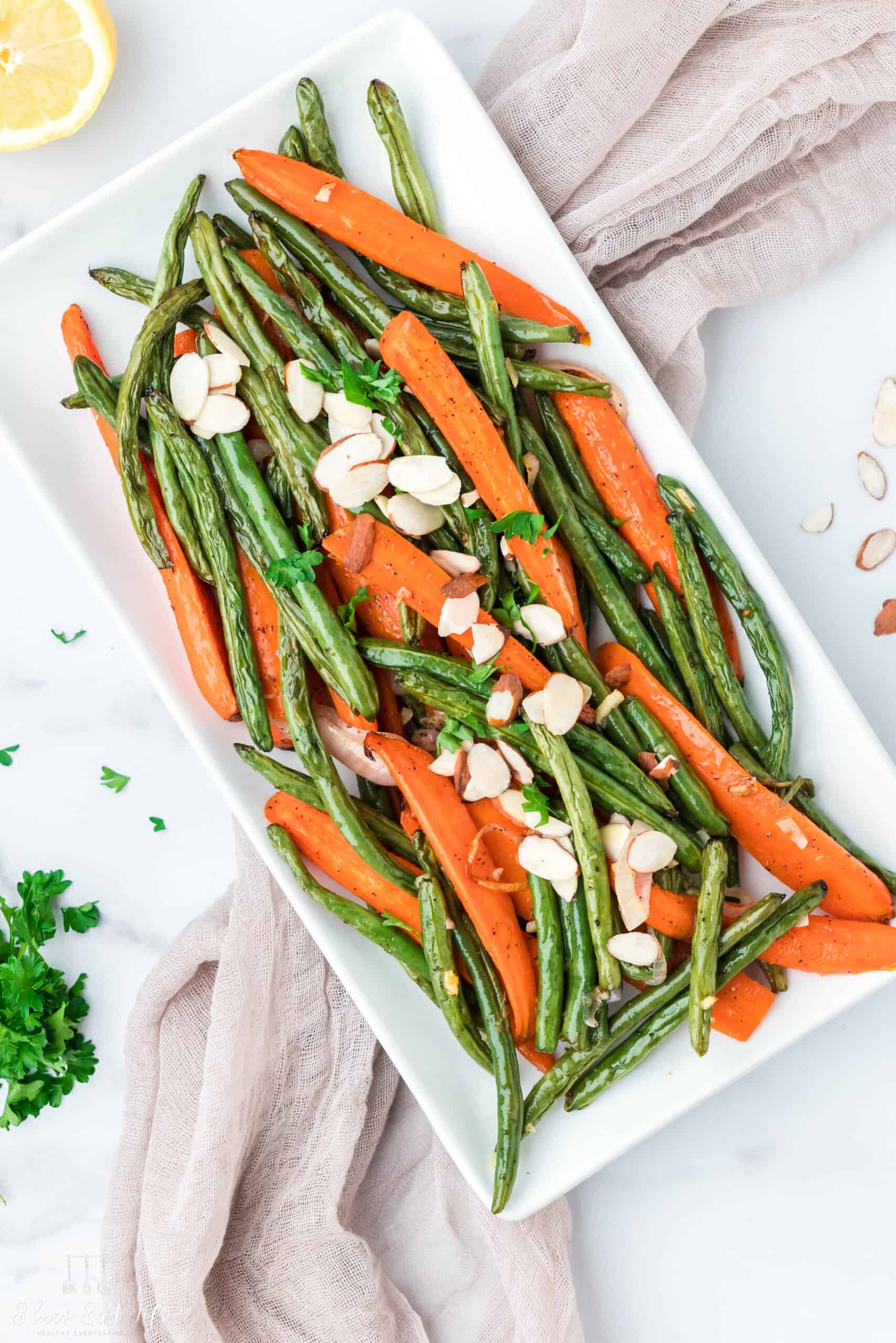 Roasted carrots and green beans on a serving platter. 