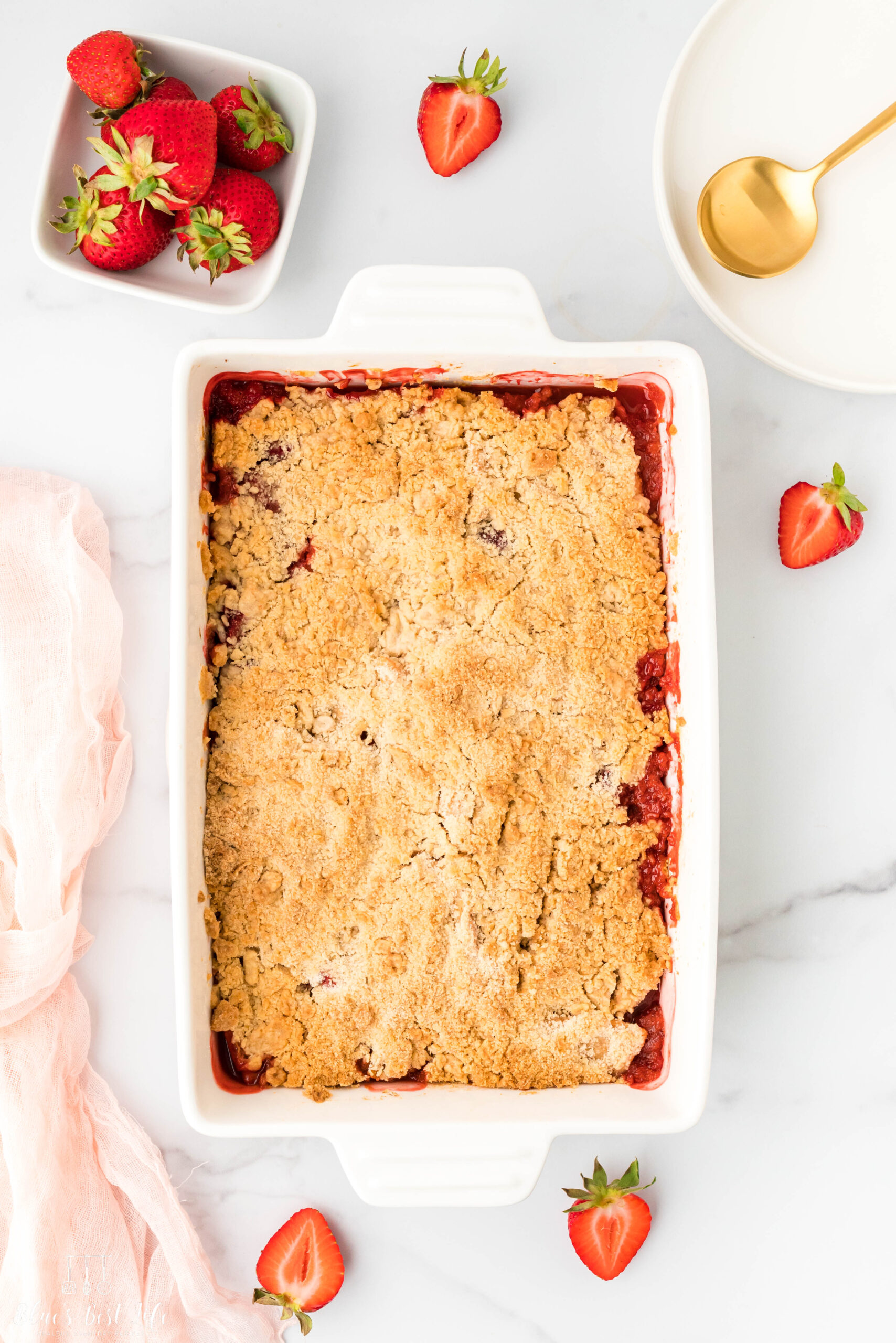 A baking dish with strawberry and apple crumble. 