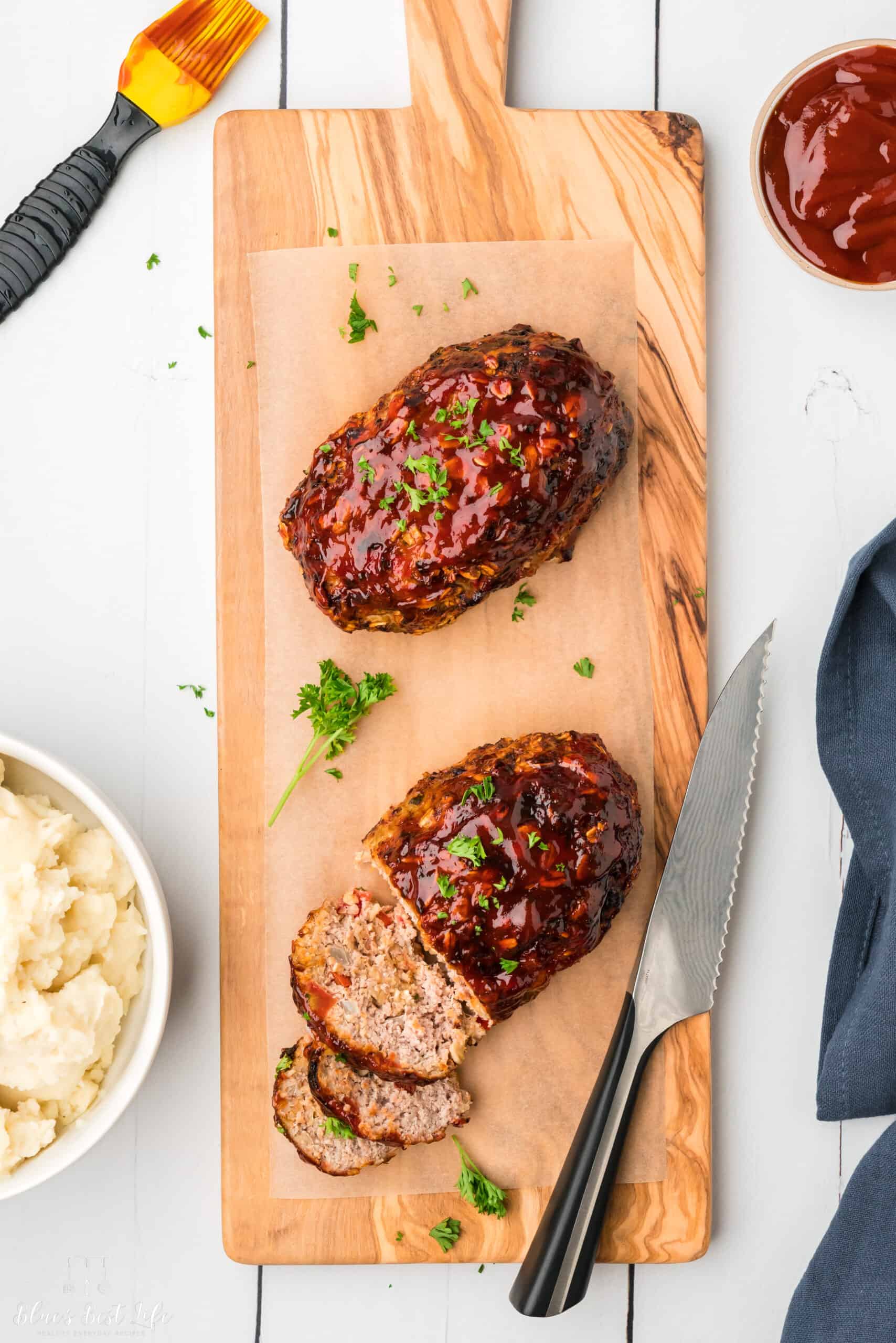 Two mini meatloaf on a cutting board.  