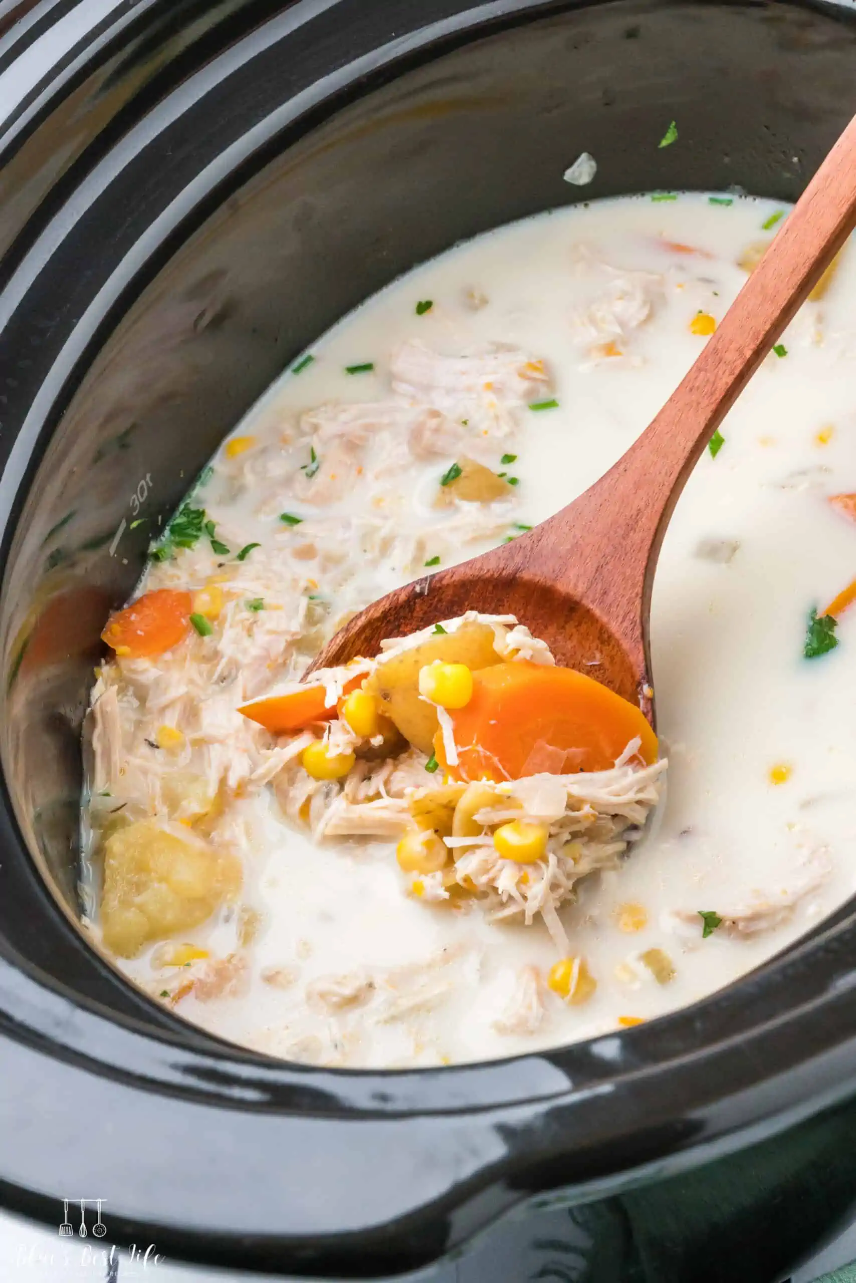 A close up of chicken and corn soup in a slow cooker. 