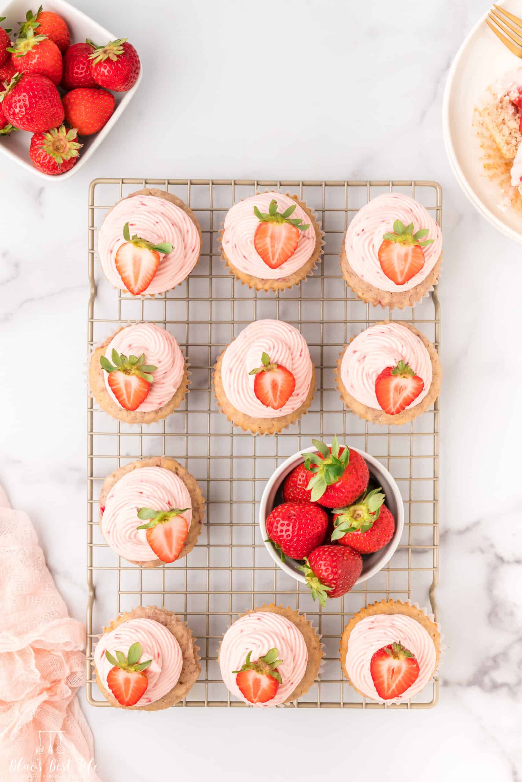 Strawberry cupcakes on a cooling rack.