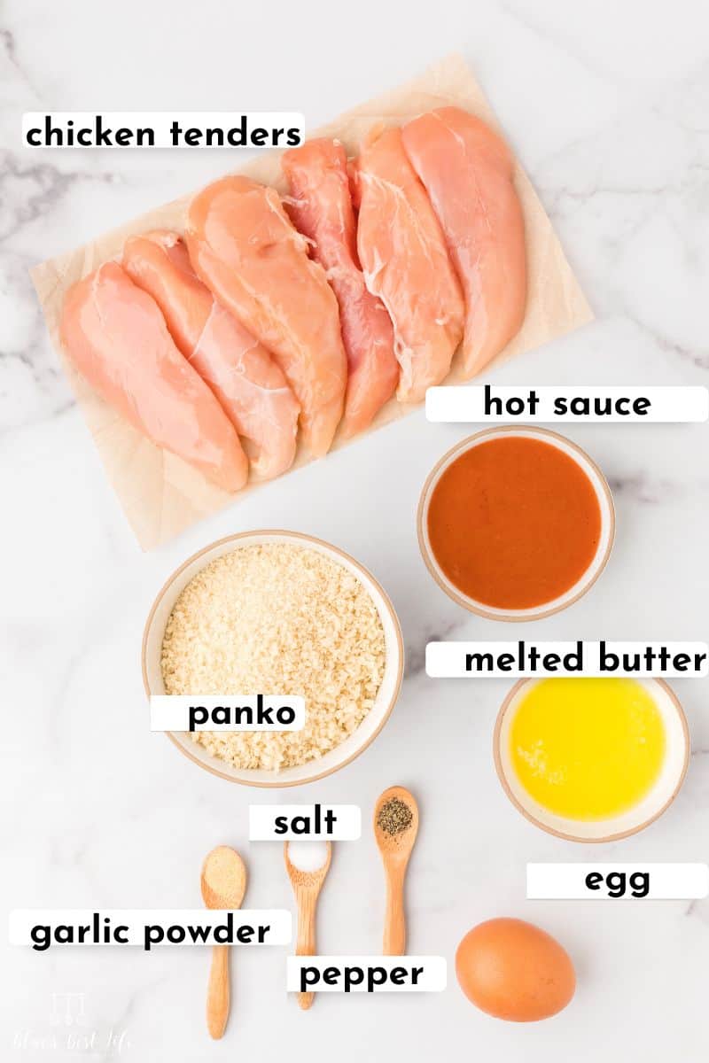 The ingredients for air fryer chicken tenders: chicken tenders, hot sauce, panko, melted butter, panko, garlic powder, salt, pepper, egg.