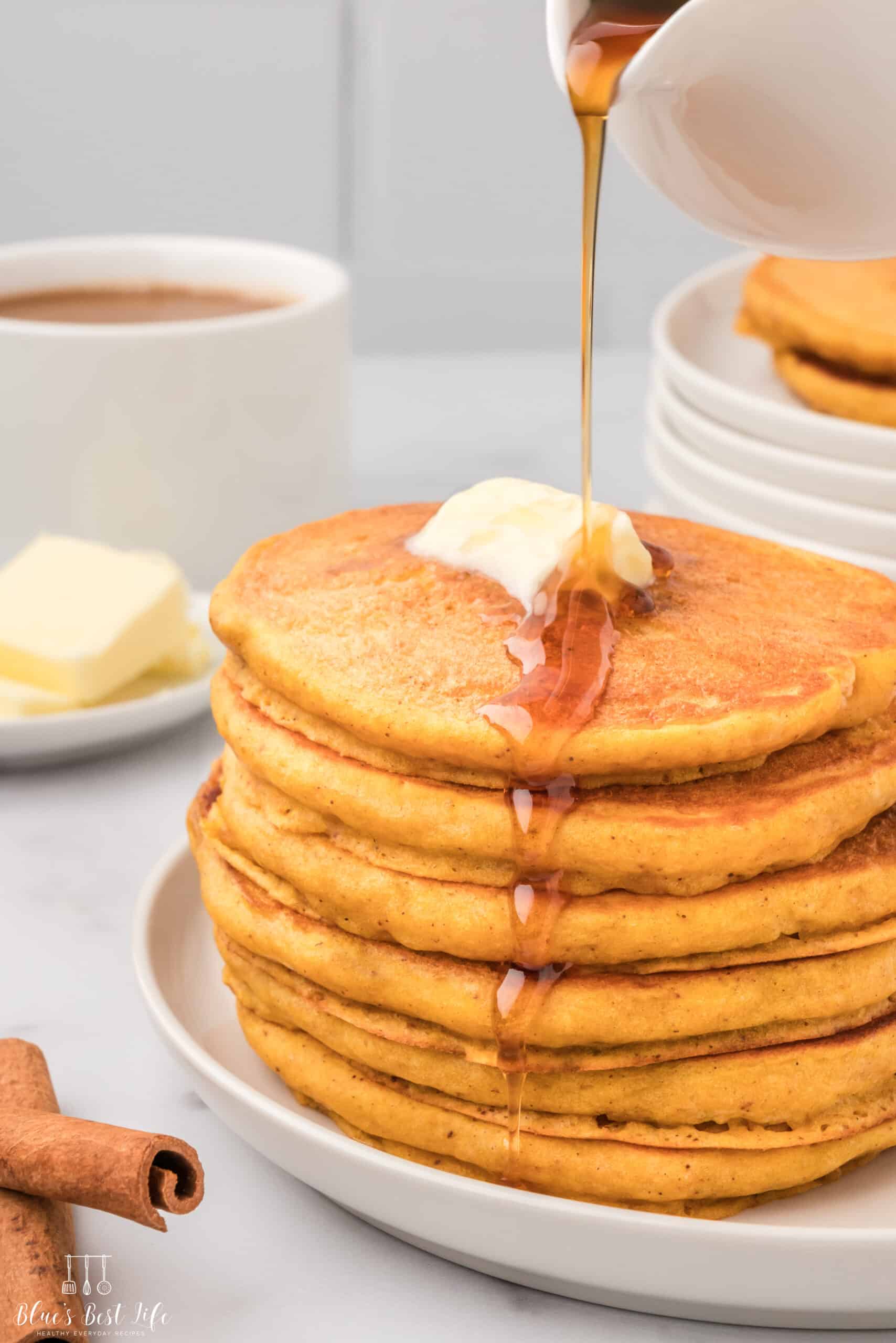 Drizzling syrup over the pancakes. 