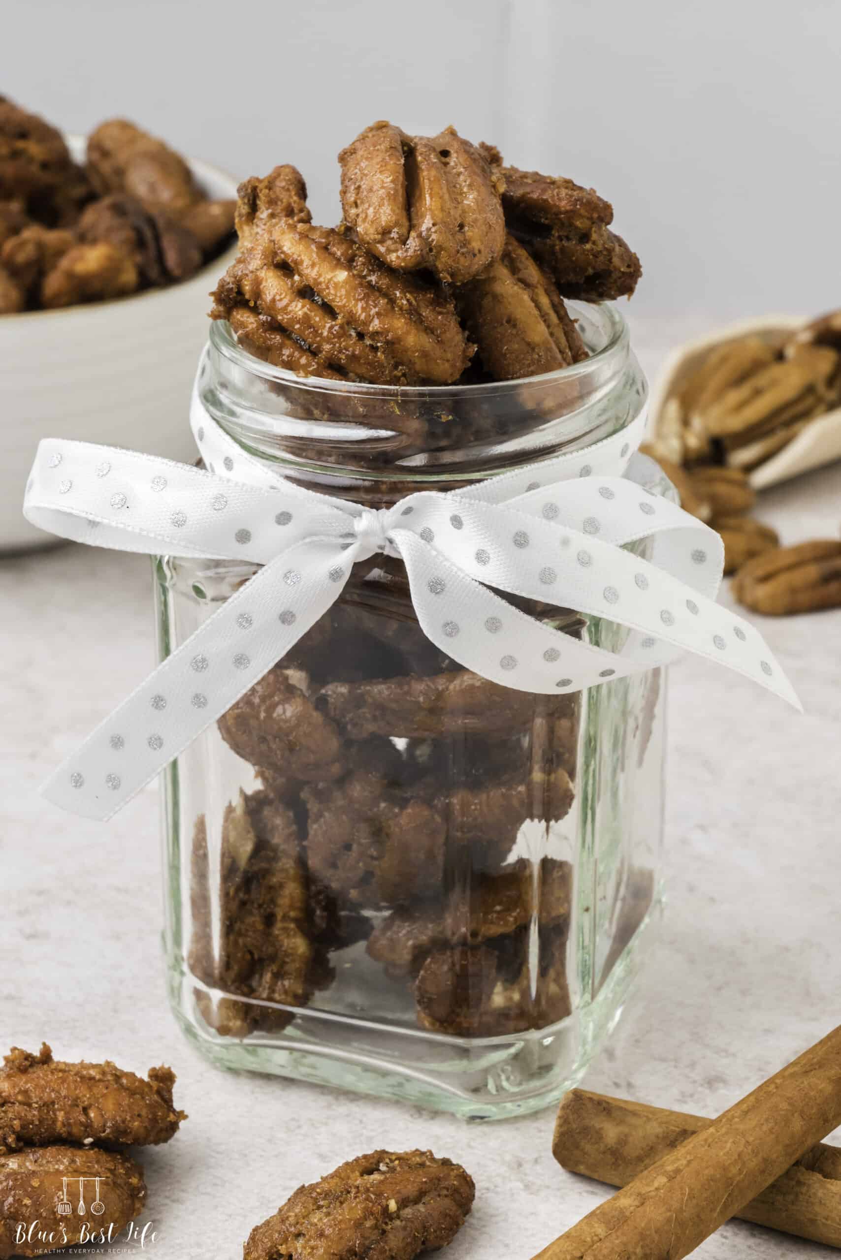 A glass gift jar with the candied pecans. 