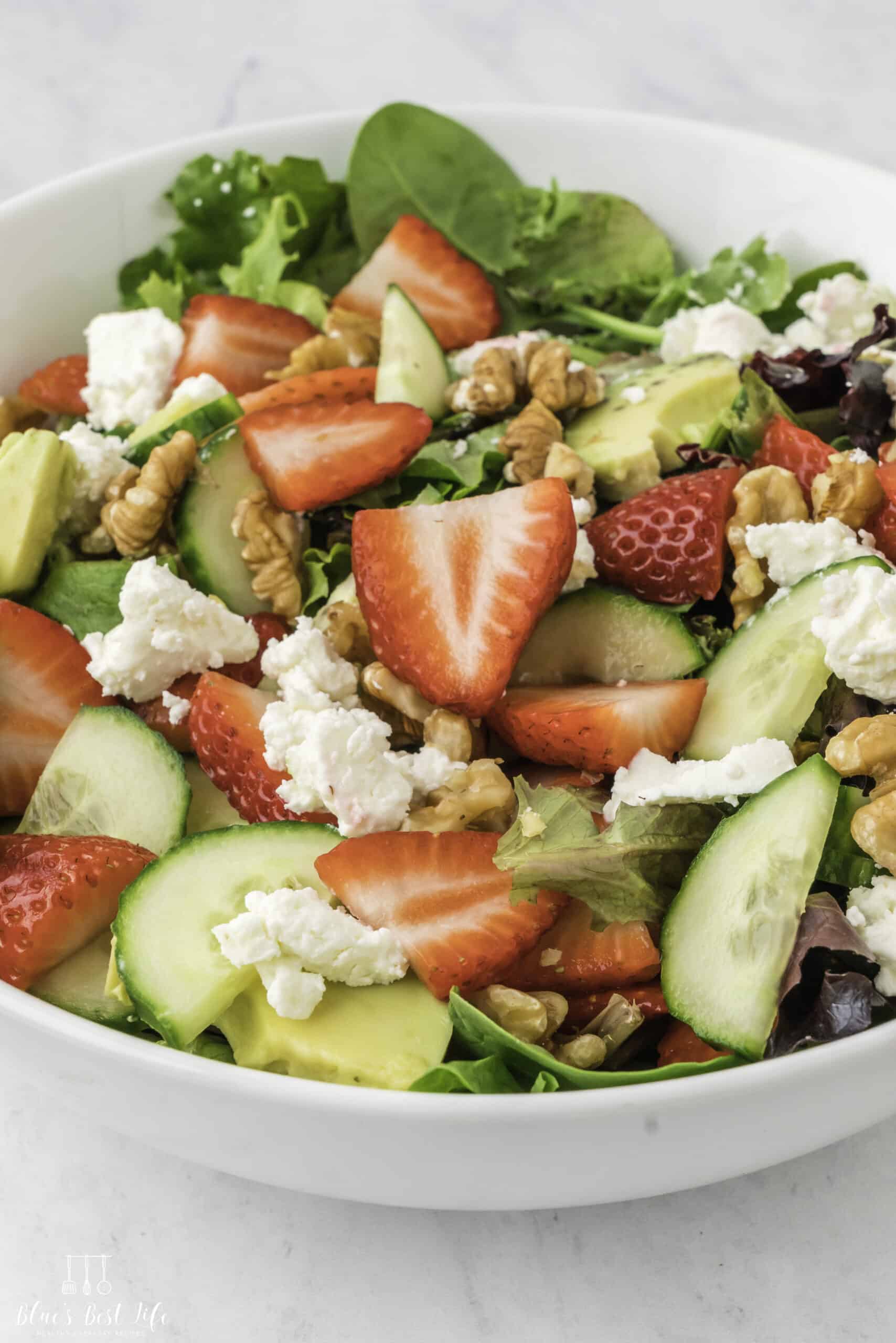The strawberry walnut salad served in a white bowl. 