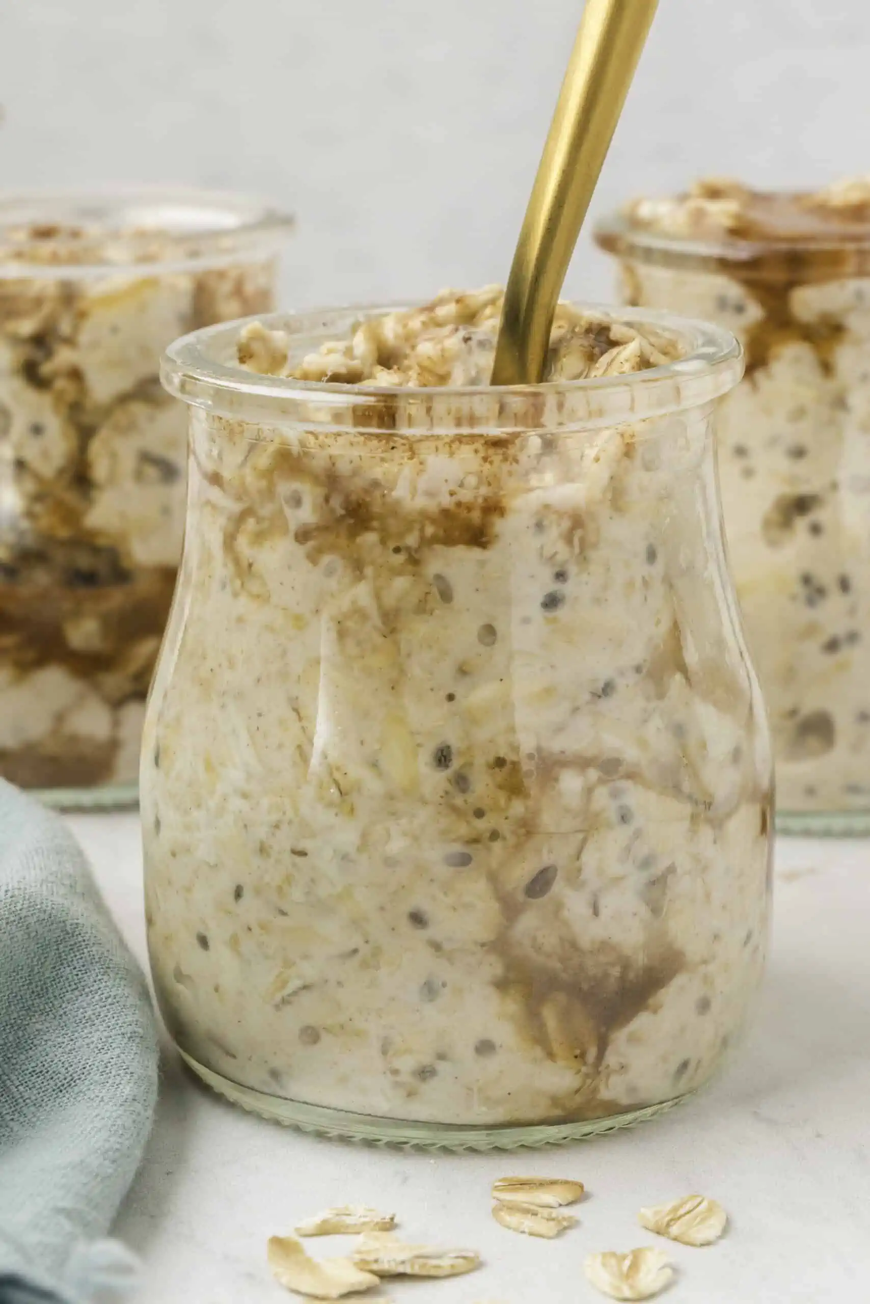 a jar with overnight oats with a spoon. 