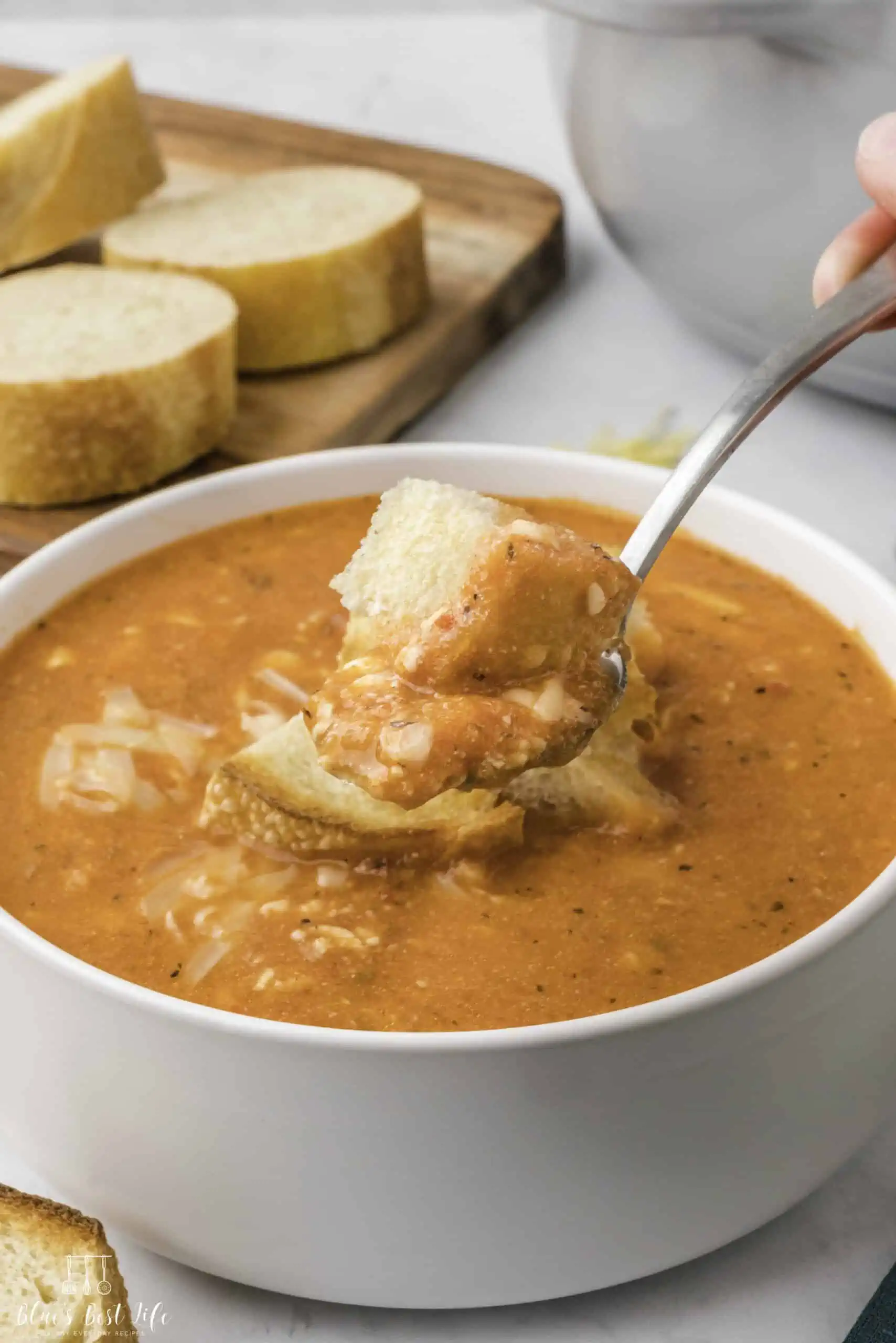 A spoonful of red pepper and gouda soup.