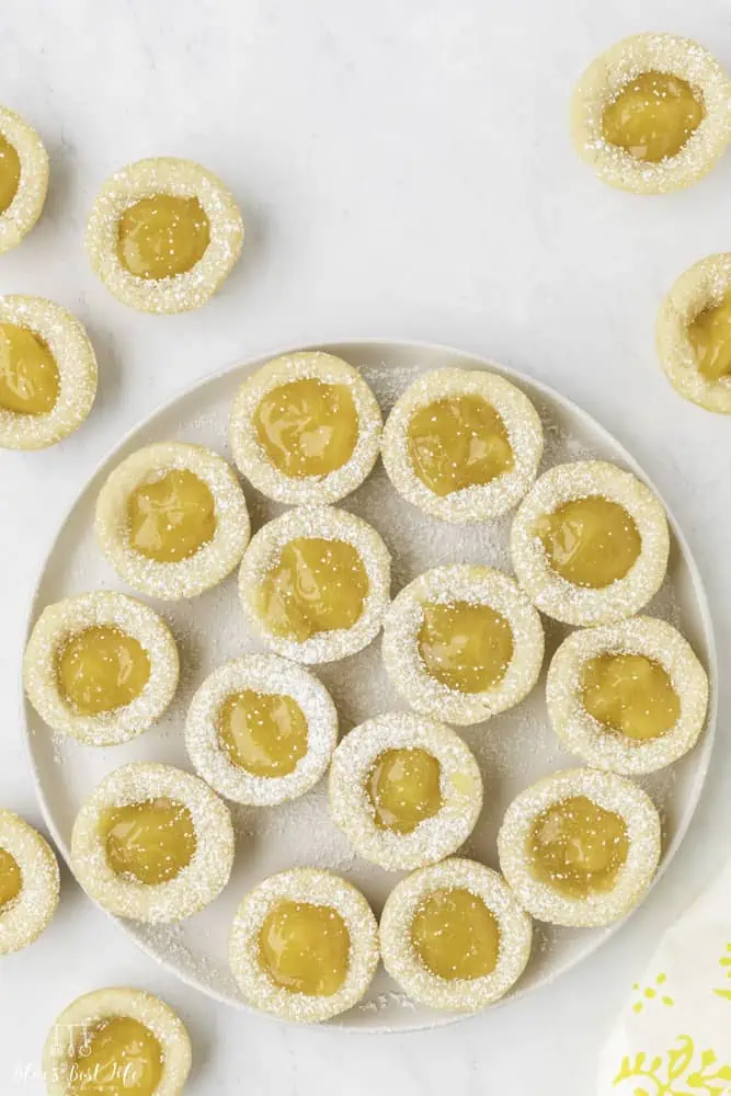 A plate of lemon curd cookies dusted with powdered sugar. 