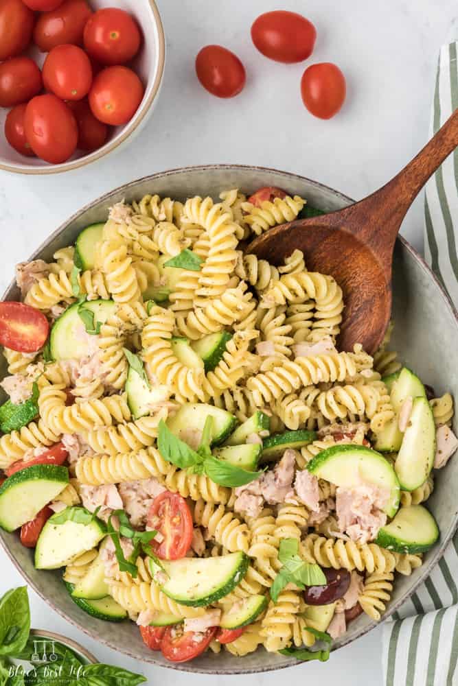 A serving bowl of the tuna pasta with a large spoon. 