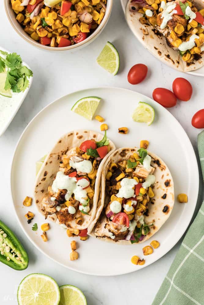 Two pieces of blackened chicken tacos on a plate. 
