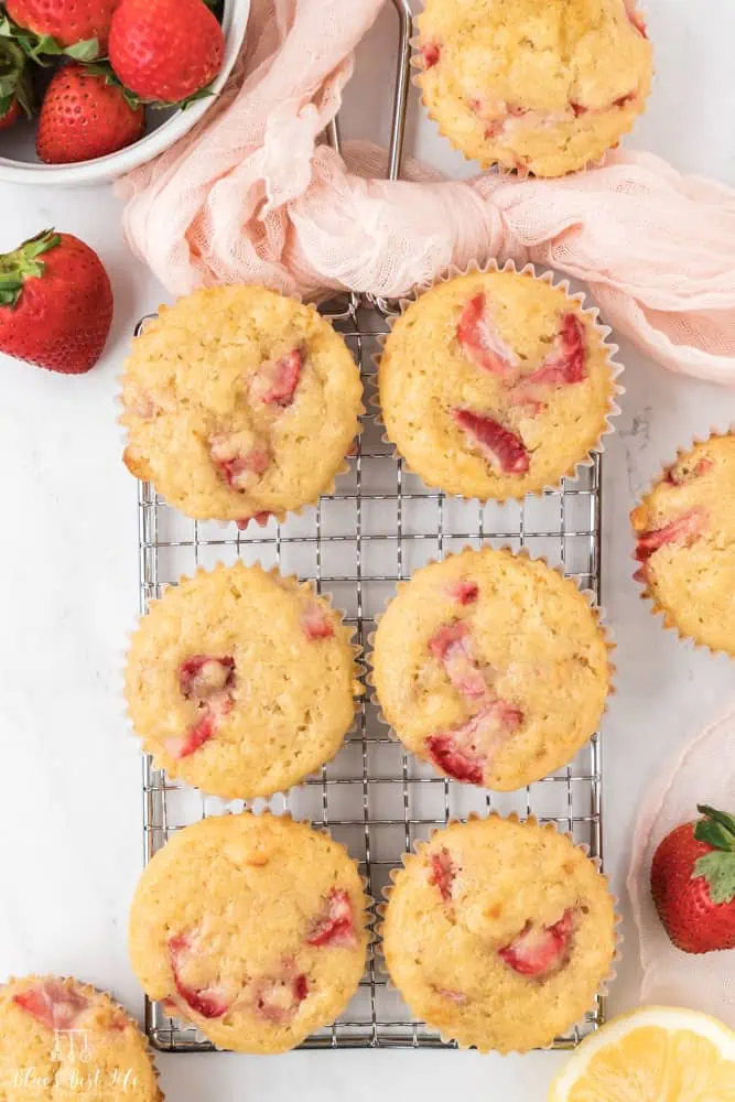 Strawberry lemon muffins cooling on a wire rack. 