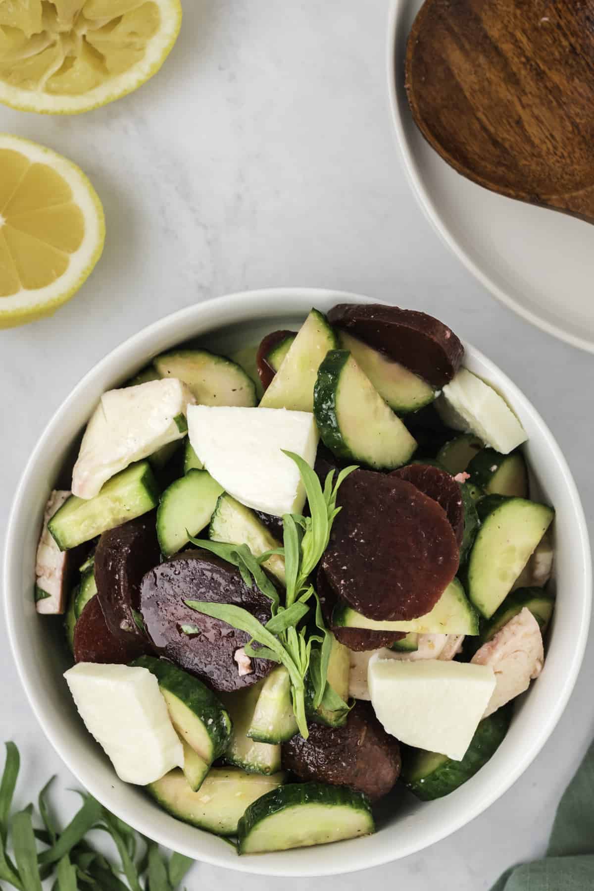 A beet and cucumber salad with mozzarella cheese and tarragon. 