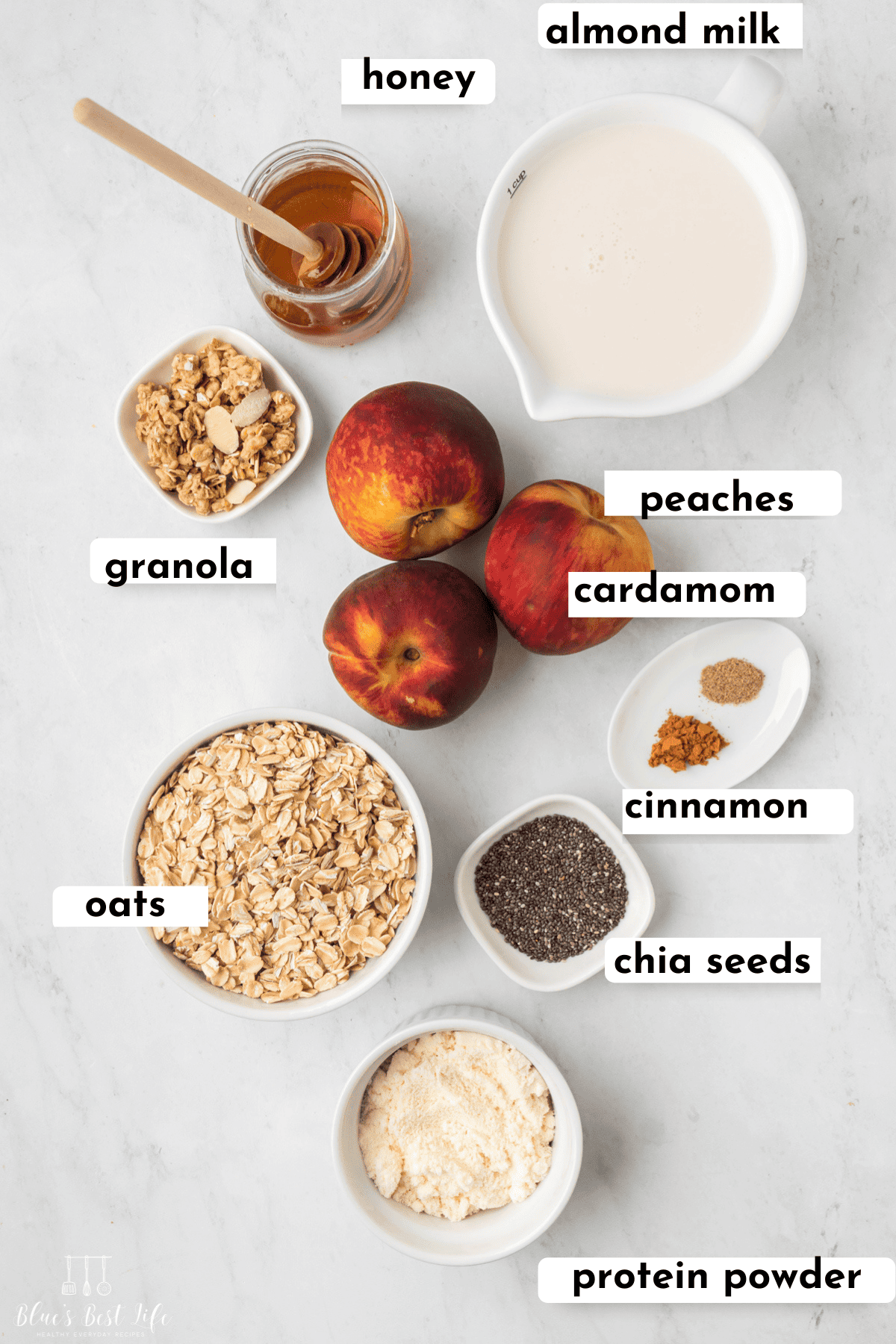 Ingredients to make peach overnight oats: almond milk, honey, granola, peaches, cardamom, cinnamon, chia seeds, oats & protein powder.