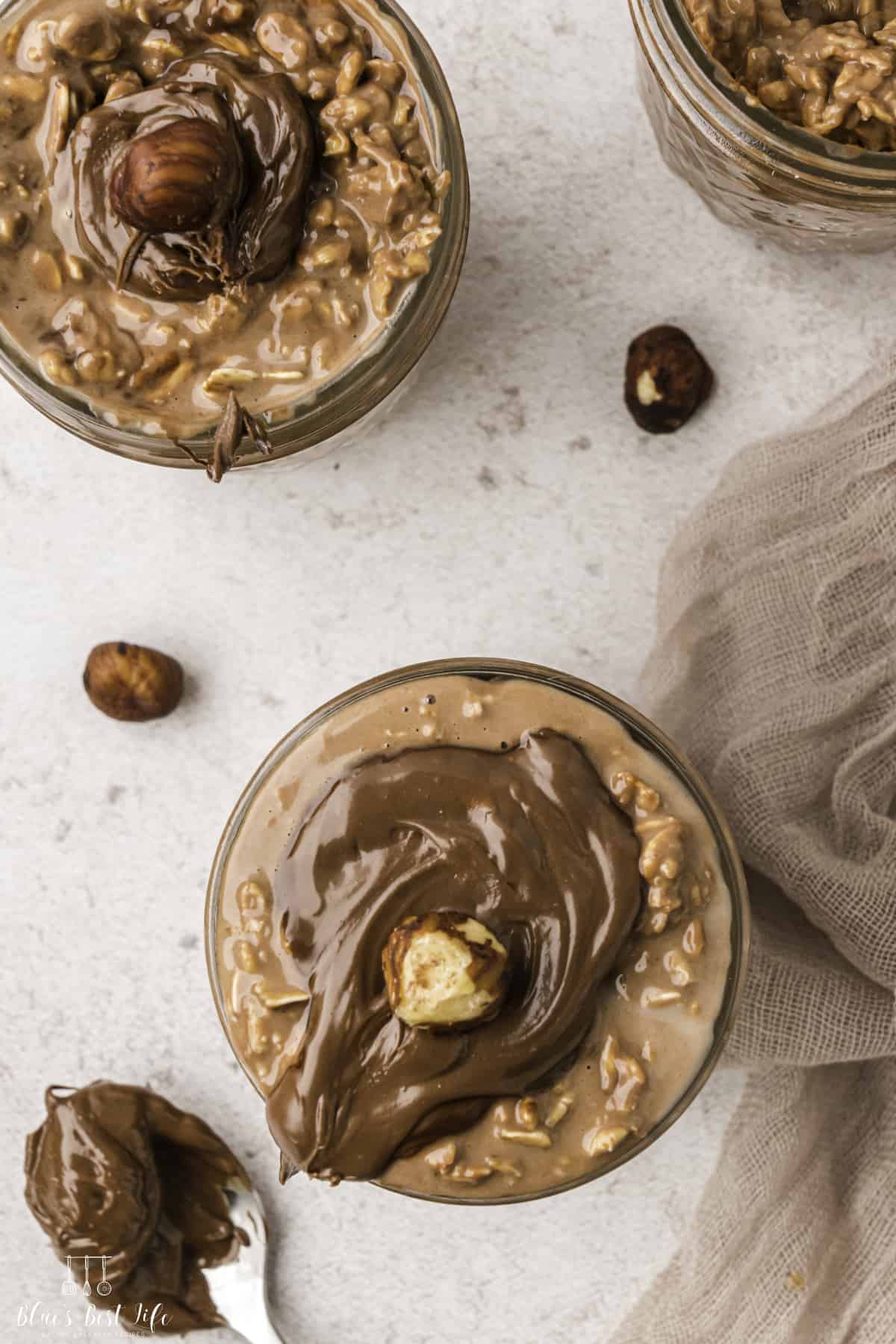 Top view shot of three servings of Mason jars with Nutella overnight oats.