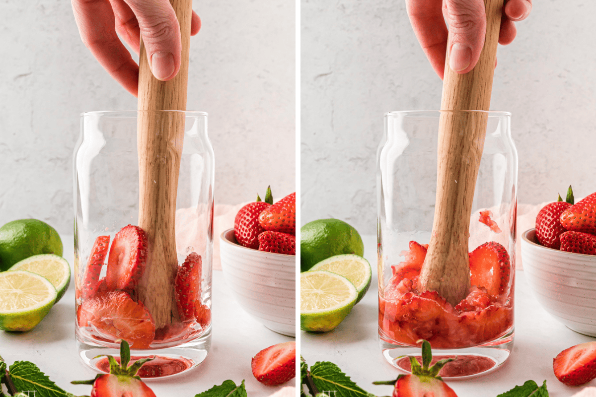 Muddling the strawberries in a clear glass with a muddler. 