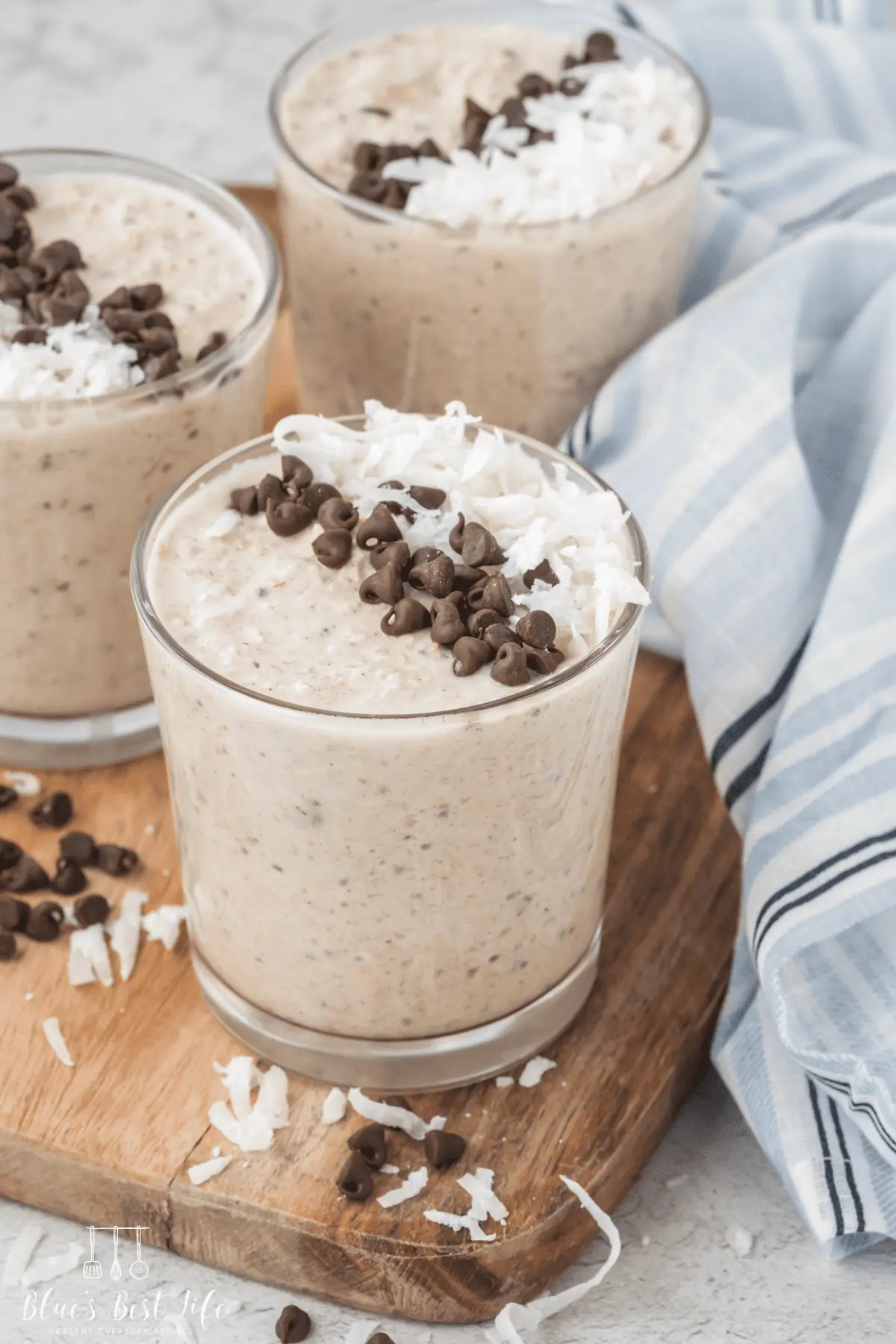 A glass jar with blended overnight oats topped with coconut and chocolate chips. 