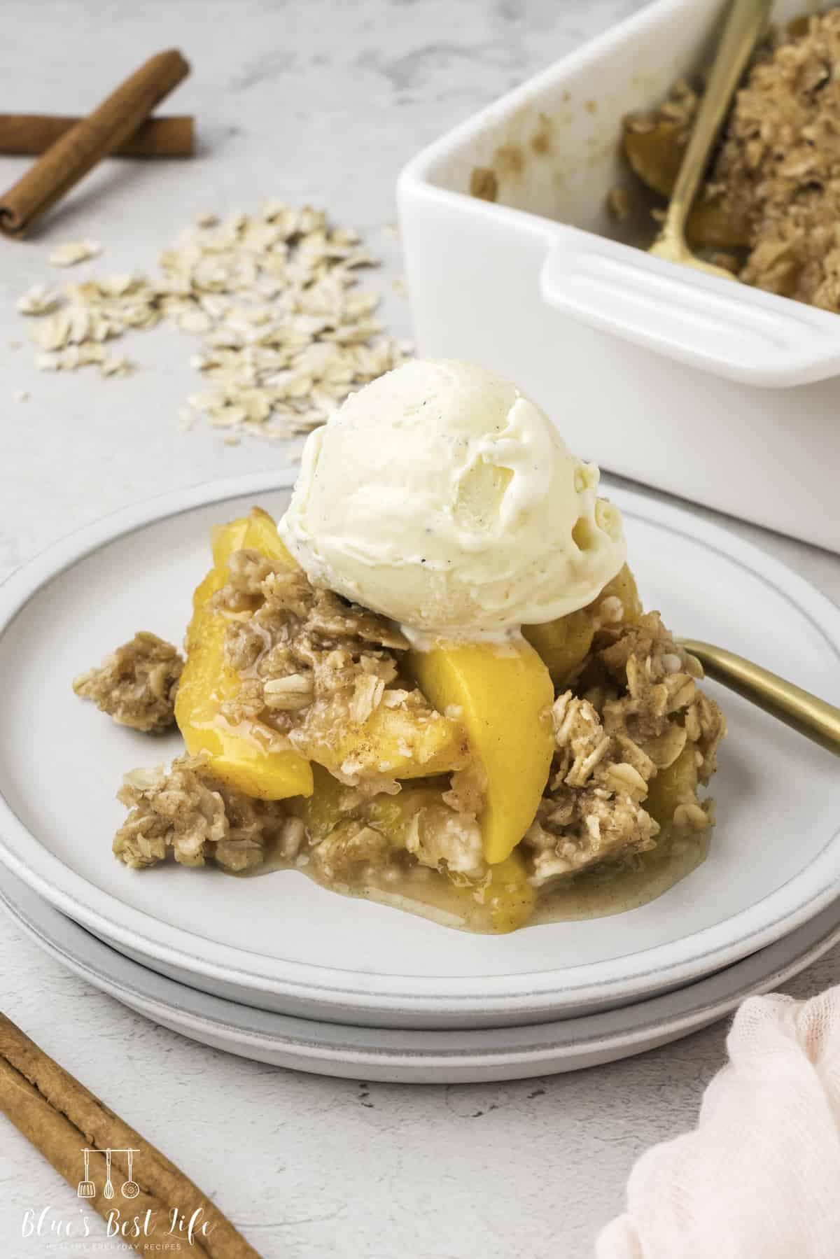 A plate with peach crisp with ice cream.