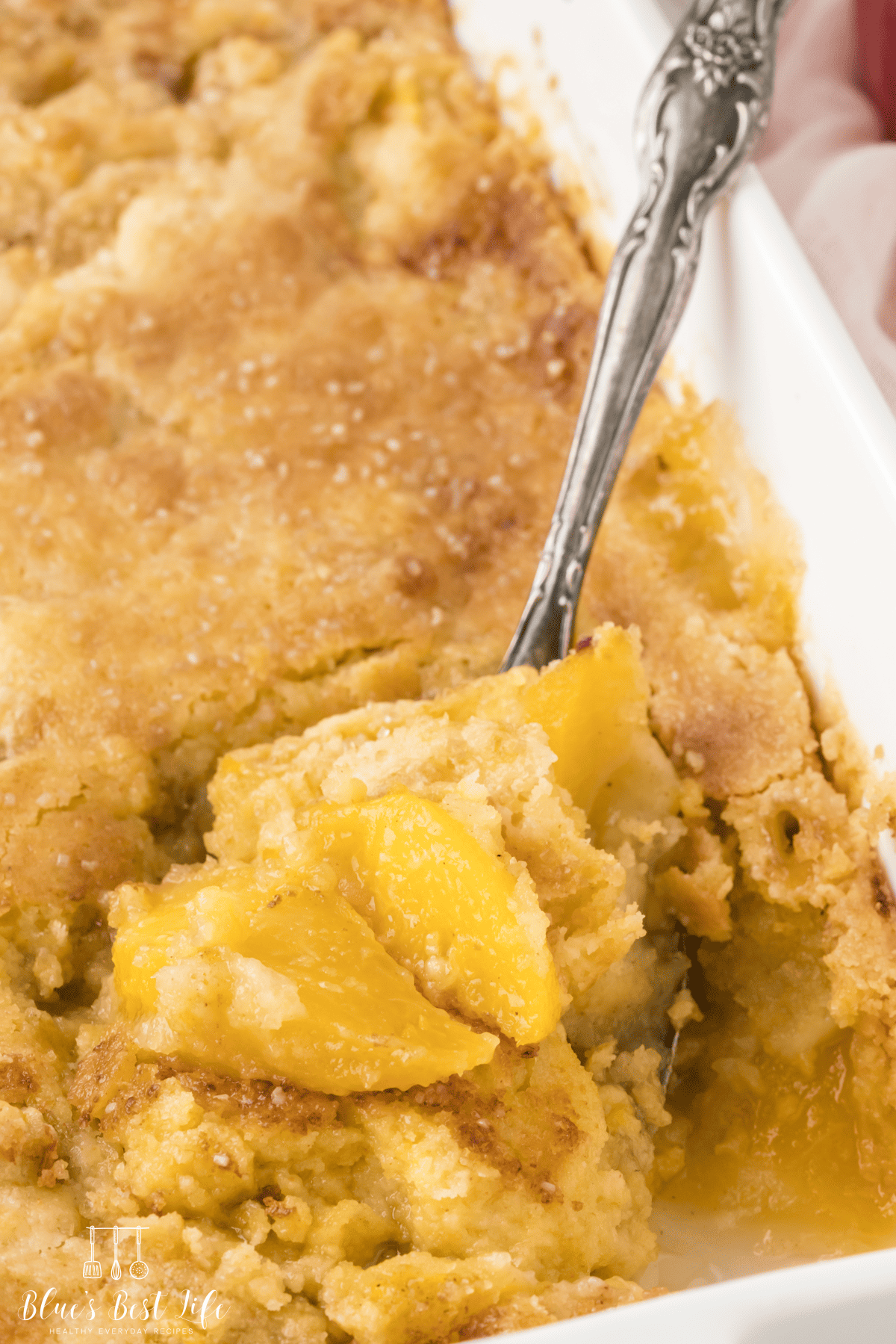 A casserole dish with peach cobbler made with cake mix. 