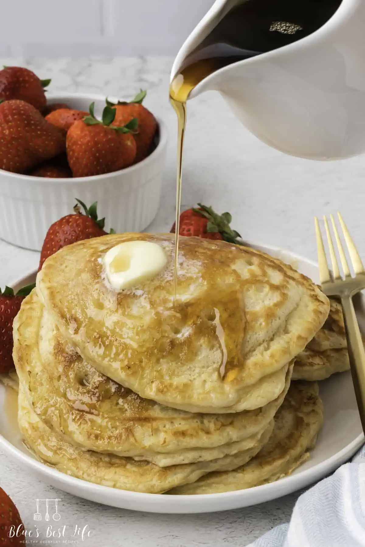 Pouring syrup on cottage cheese pancakes.  