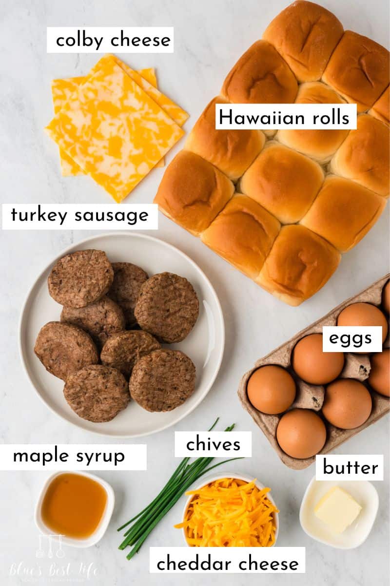 The ingredients to make the breakfast sliders: Colby Cheese, Hawaiian rolls, turkey sausage, eggs, maple syrup, chives, cheddar cheese, eggs & butter.