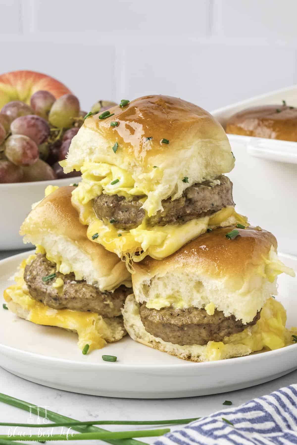 A stack of breakfast sliders on a  white plate. 