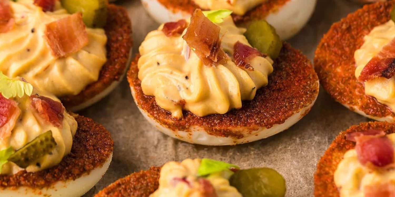 deviled eggs decoarated with pickle and bacon