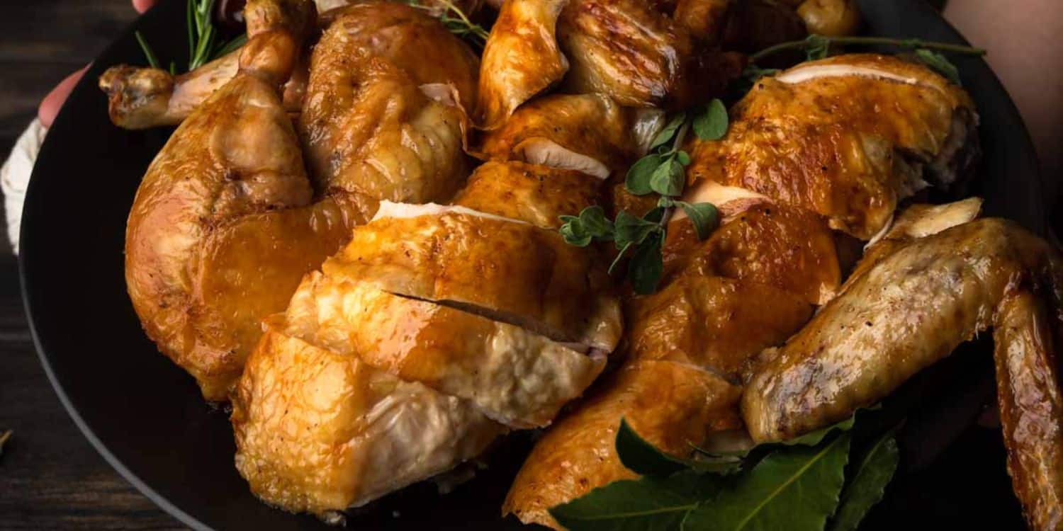 A close-up shot of Roasted Chicken, cut into serving pieces and served on a bowl. 