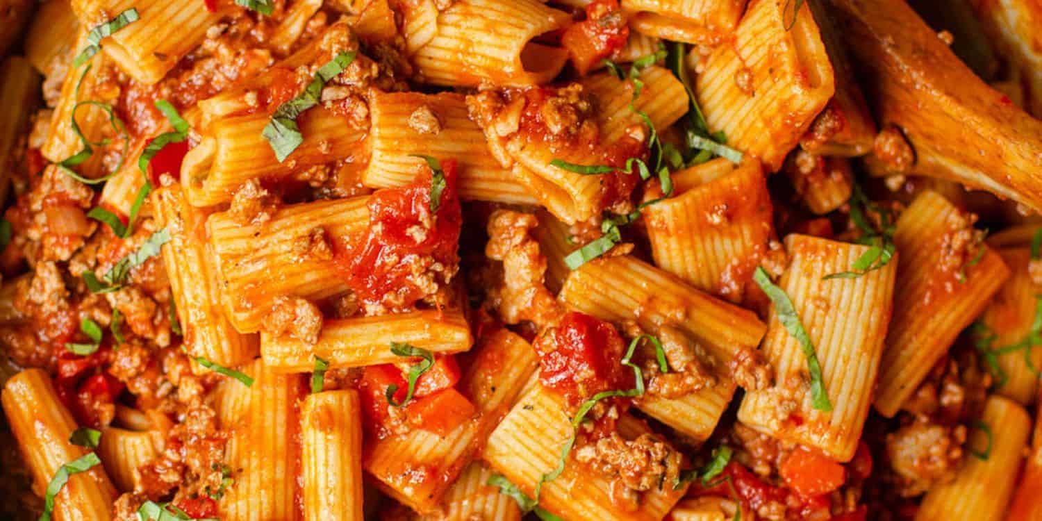 A close-up shot of Rigatoni Bolognese pasta. 