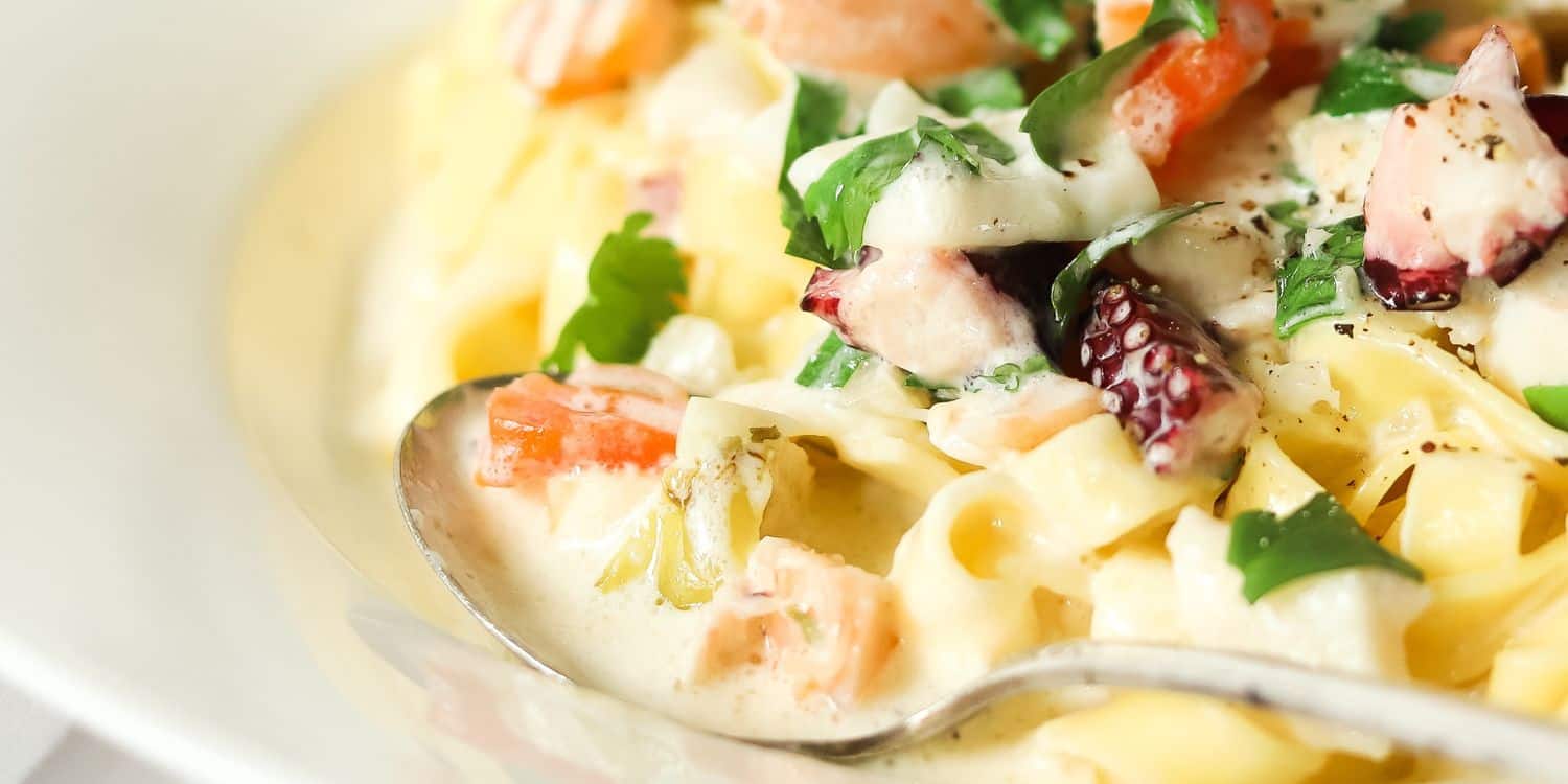 Close-up shot of Seafood alfredo on a bowl.