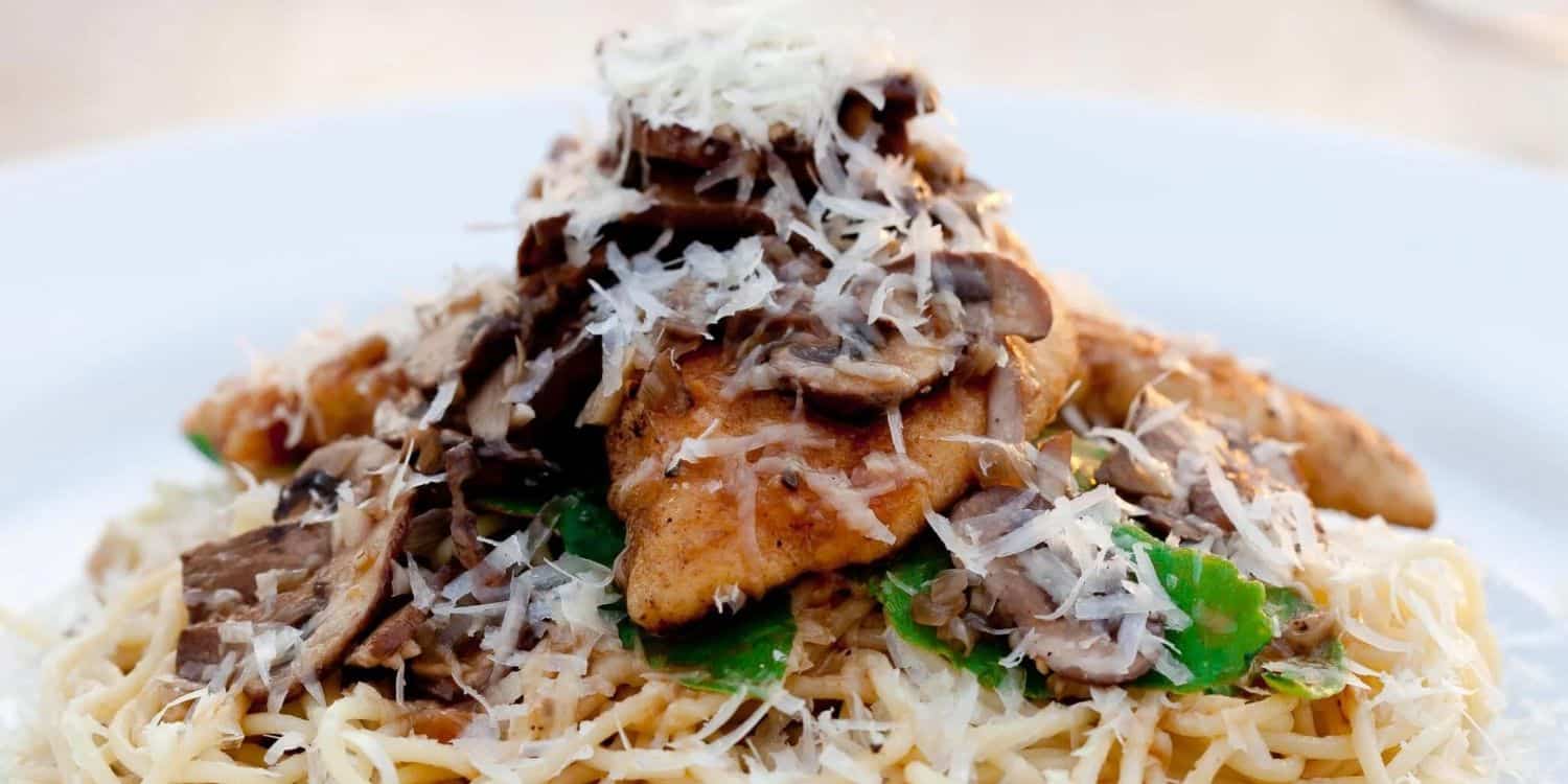 close-up shot of Chicken marsala with pasta served on a plate.