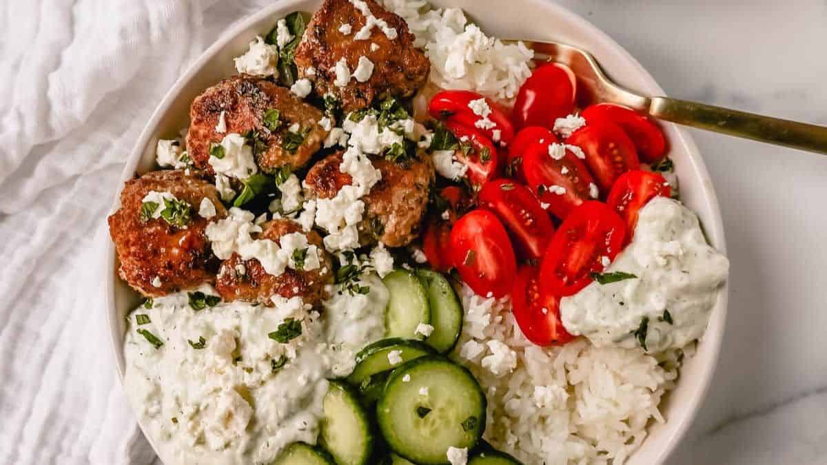 Greek Chicken Meatballs Bowls With Tzatziki Sauce served over a bowl of rice. 